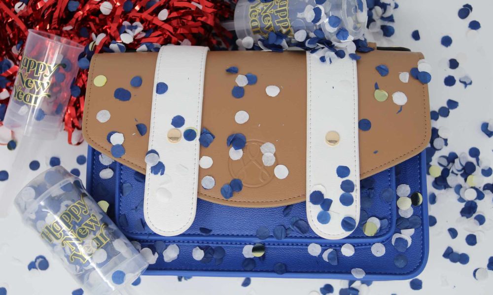 Waterloo Bags handbag surrounded by blue and white confetti celebrating a year of growth, community, and creativity