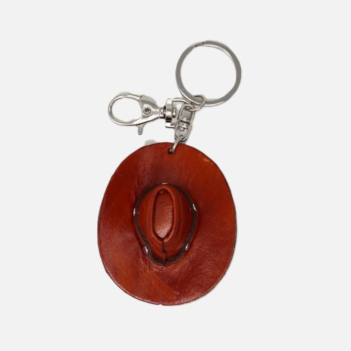 Brown leather purse charm with a cowboy hat design on a white background