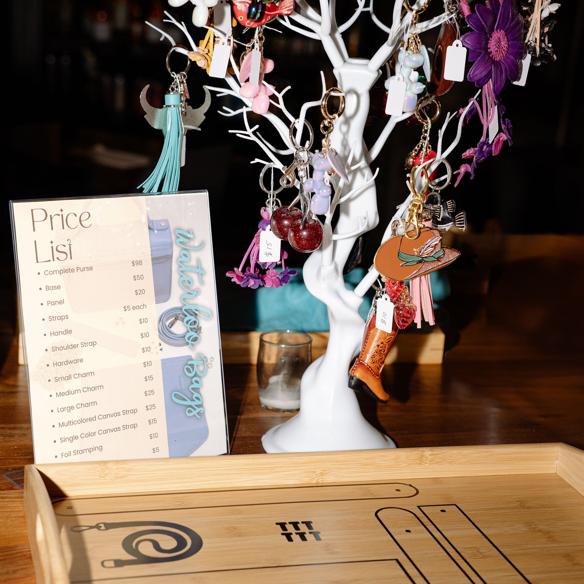 Earring tree with various earrings and a price list on a wooden surface